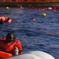 14.11.16 View from a rescue boat of the SAR-Team. A woman in a rubber boat waiting to be rescued by the SAR-Team. Other migrants holding on to floating devices in the water.